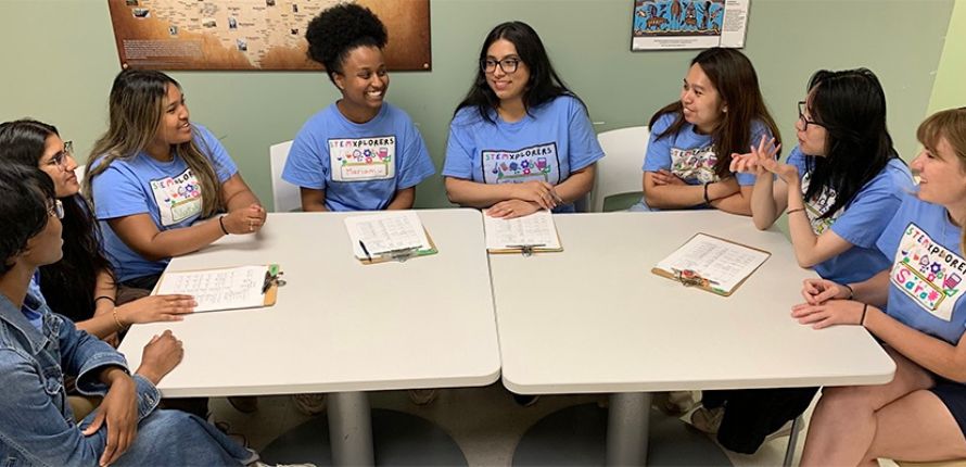 Female camp counsellors sitting around a table. 